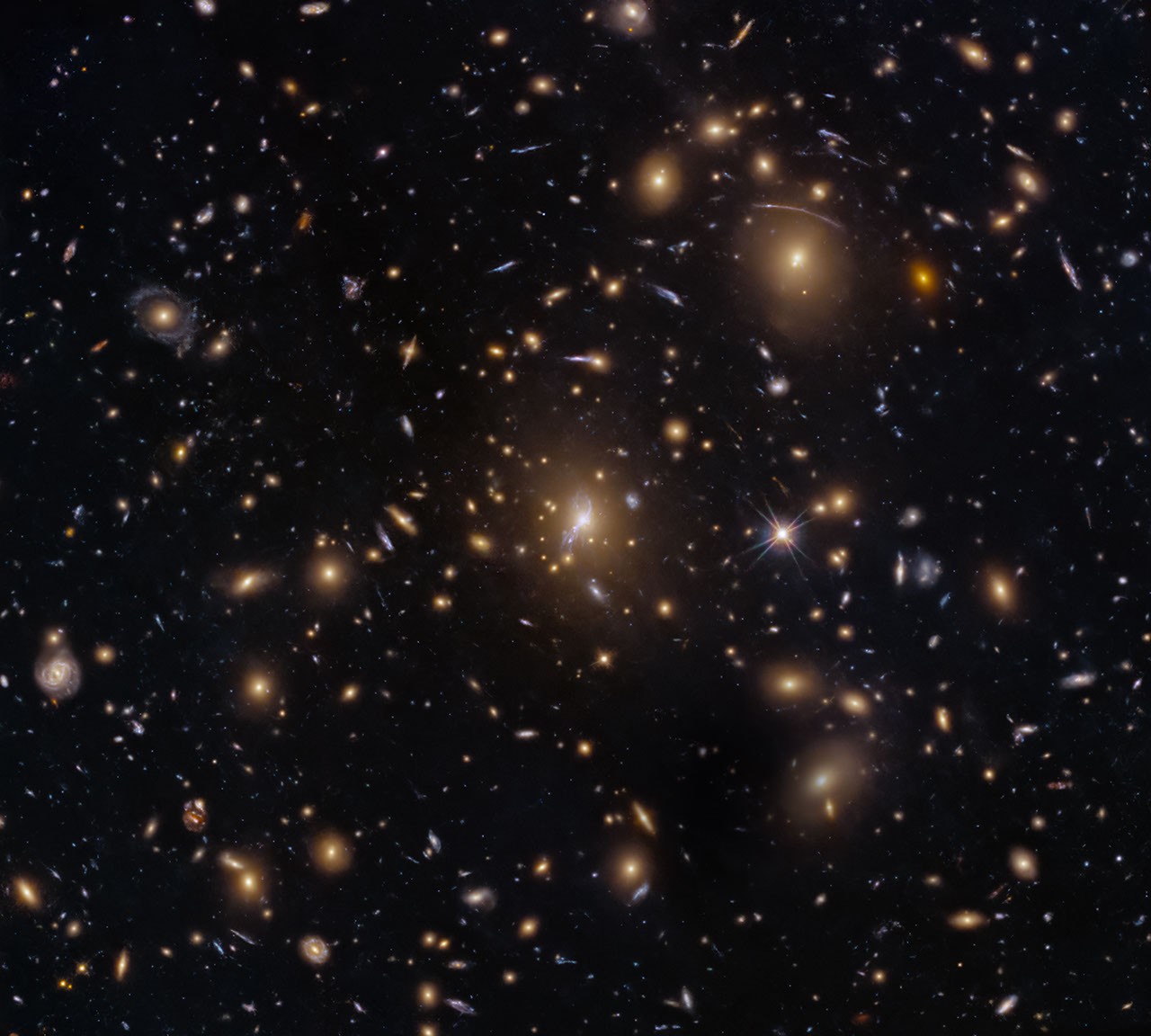Imagen del cúmulo de galaxias MACS0329-0211 con numerosas galaxias y arcos de luz de objetos más lejanos distorsionados por gravedad